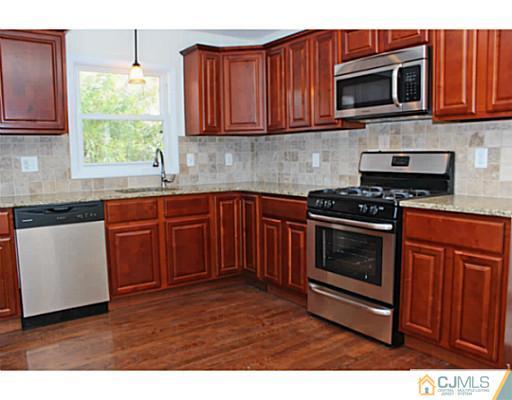 202 Jackson Avenue Edison, NJ 08837 - Photo 5 of 17 a kitchen with stainless steel appliances granite countertop a stove a sink dishwasher and a microwave