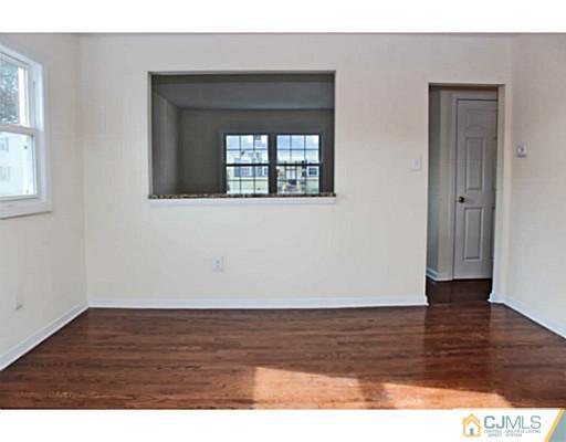 202 Jackson Avenue Edison, NJ 08837 - Photo 7 of 17 a view of an empty room with wooden floor and a window