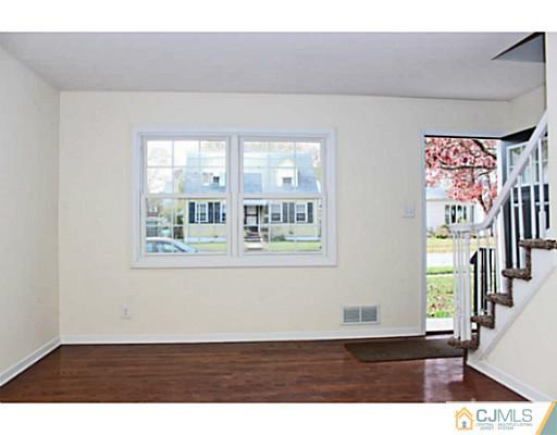 202 Jackson Avenue Edison, NJ 08837 - Photo 8 of 17 a view of an empty room with wooden floor and a window
