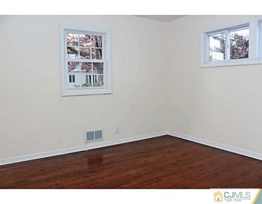 202 Jackson Avenue Edison, NJ 08837 - Photo 10 of 17 an empty room with wooden floor and hallway