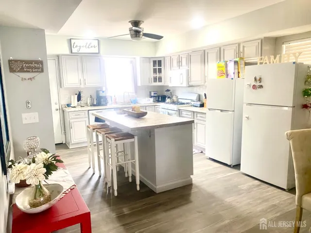 a kitchen with stainless steel appliances a refrigerator a sink a stove a dining table and chairs