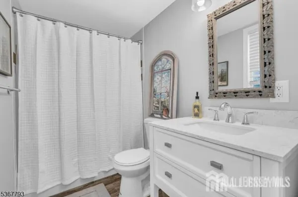 a bathroom with a sink a toilet and a mirror