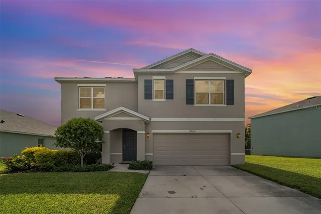 a front view of a house with a yard and garage