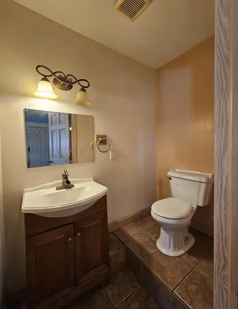 a bathroom with a toilet a sink and mirror