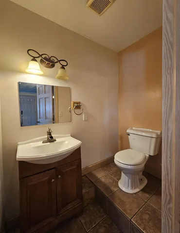 a bathroom with a toilet a sink and mirror