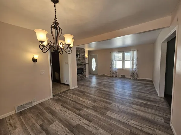 a view of a room with wooden floor and chandelier