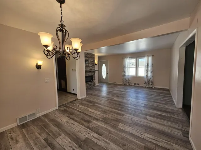 a view of a room with wooden floor and chandelier