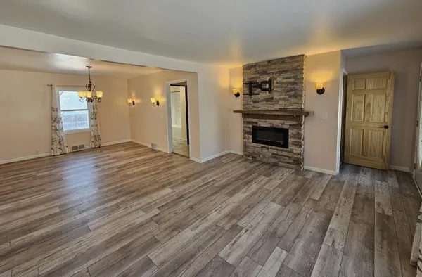 wooden floor fireplace and windows in an empty room