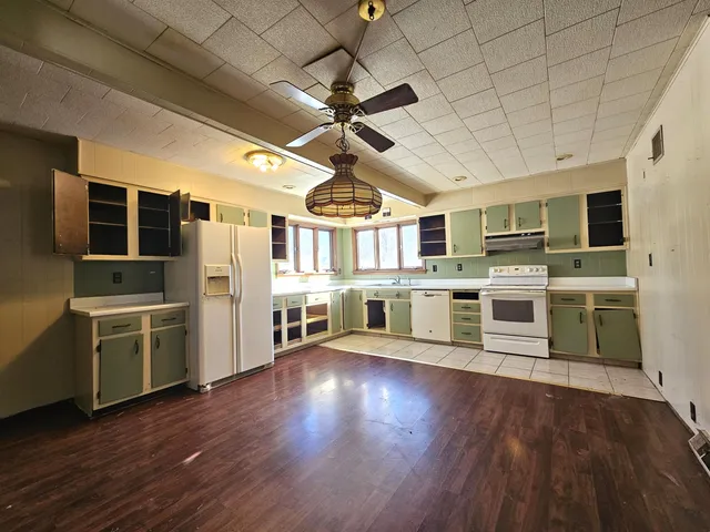 a kitchen with stainless steel appliances wooden floors stove and refrigerator