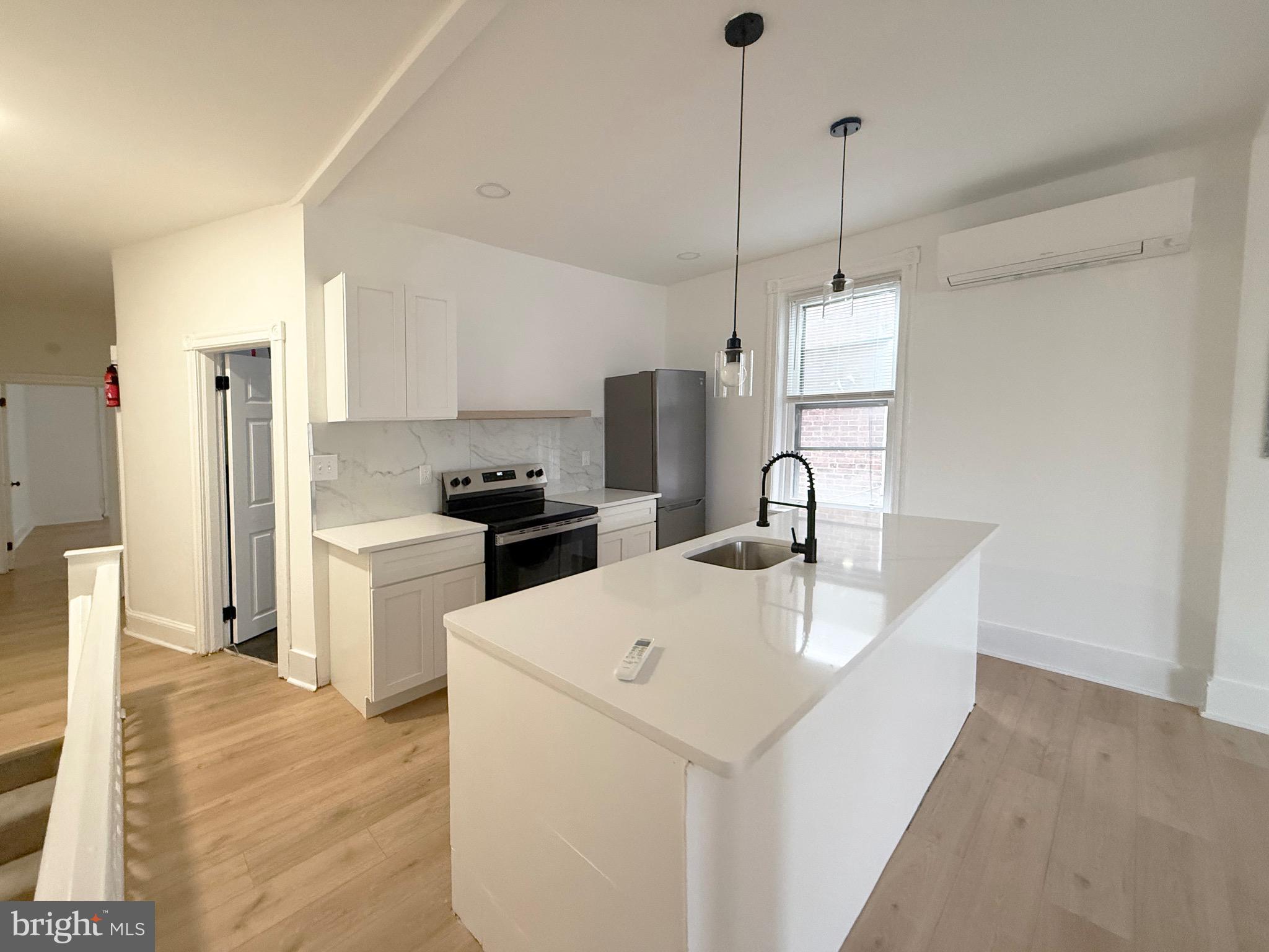 114 South 58th Street, Unit 2 Philadelphia, PA 19139 - Photo 1 of 10 a kitchen with stainless steel appliances granite countertop a sink a refrigerator and a stove
