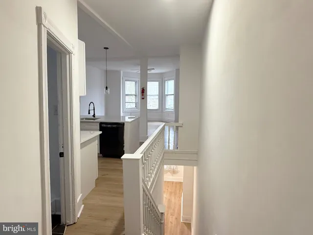 a view of a hallway with wooden floor and staircase