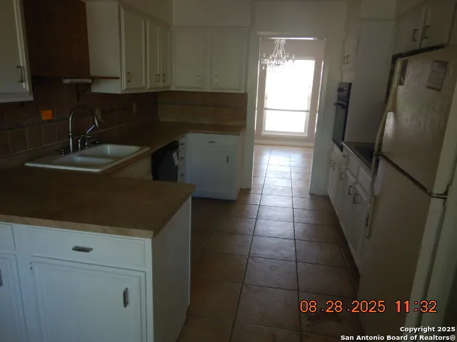 a kitchen with a sink a refrigerator and cabinets