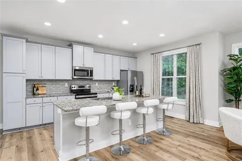 a kitchen with a dining table chairs and refrigerator