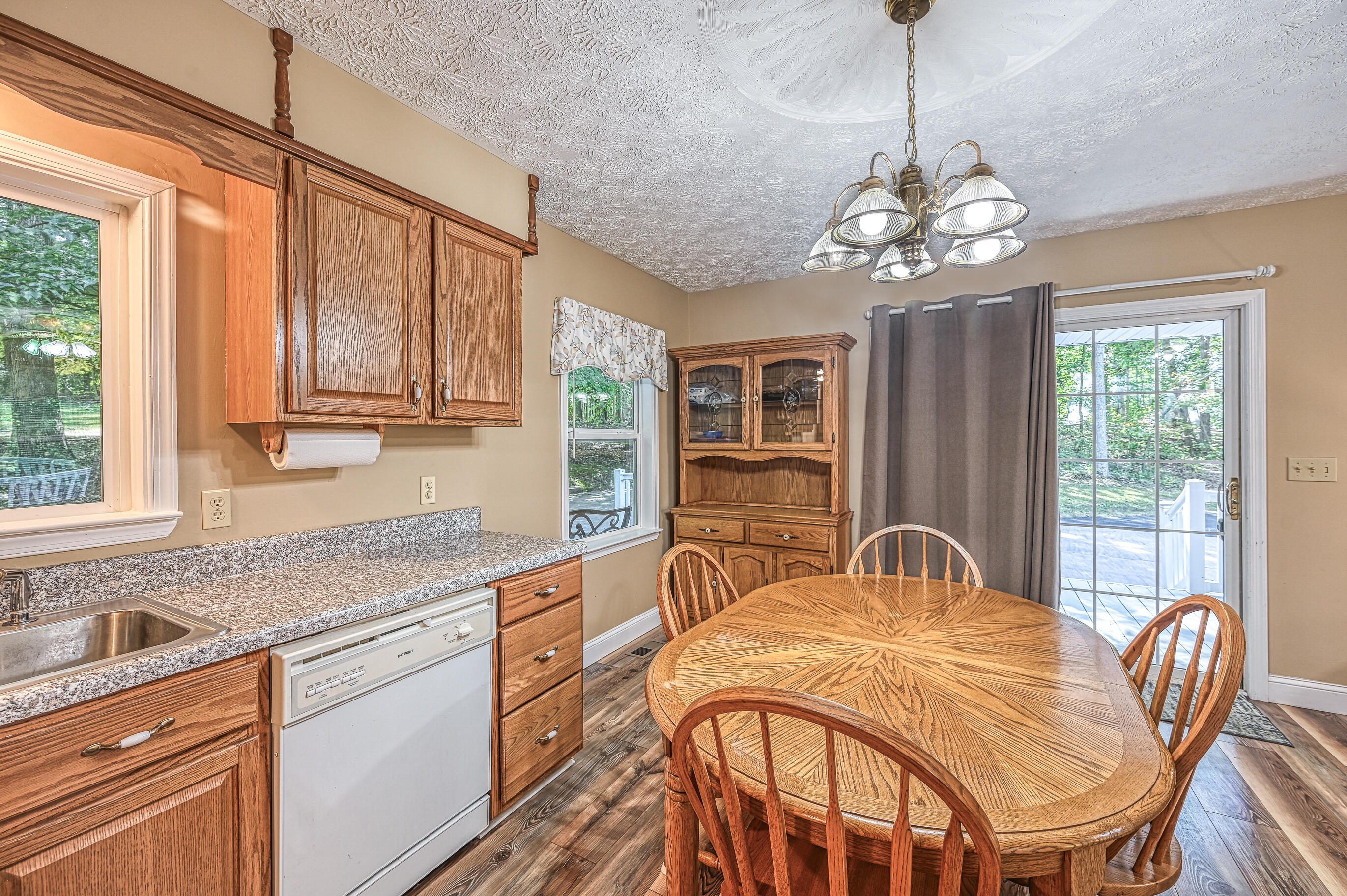 206 Oak Road Bumpass, VA 23024 - Photo 12 of 38 a view of a kitchen with granite countertop a sink stainless steel appliances dining table and wooden floor