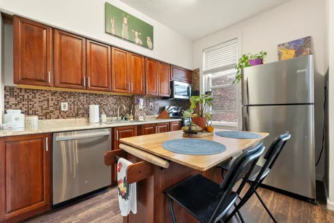 a kitchen with a table chairs refrigerator and cabinets