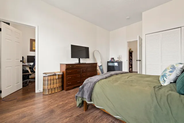 a bedroom with a bed and wooden floor