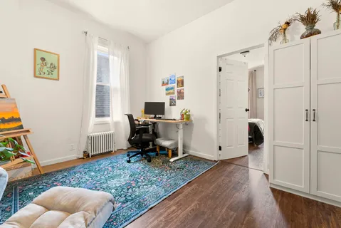 a view of workspace with wooden floor and white cabinet