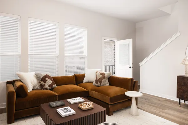 a living room with furniture kitchen view and a large window
