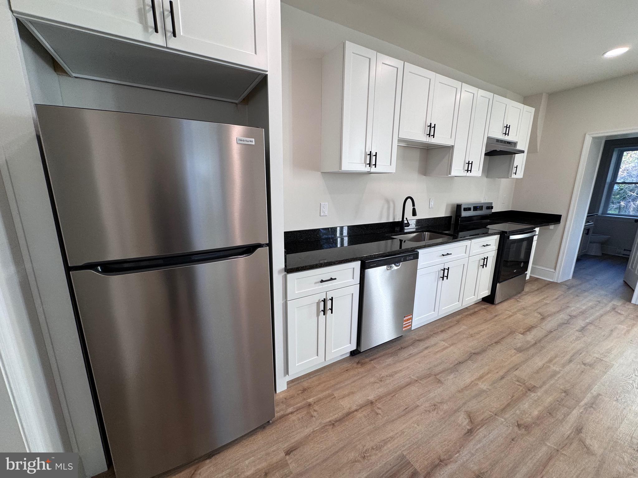 666 St Joseph Street, Unit 1A Lancaster, PA 17603 - Photo 1 of 8 a kitchen with stainless steel appliances a refrigerator a sink and white cabinets
