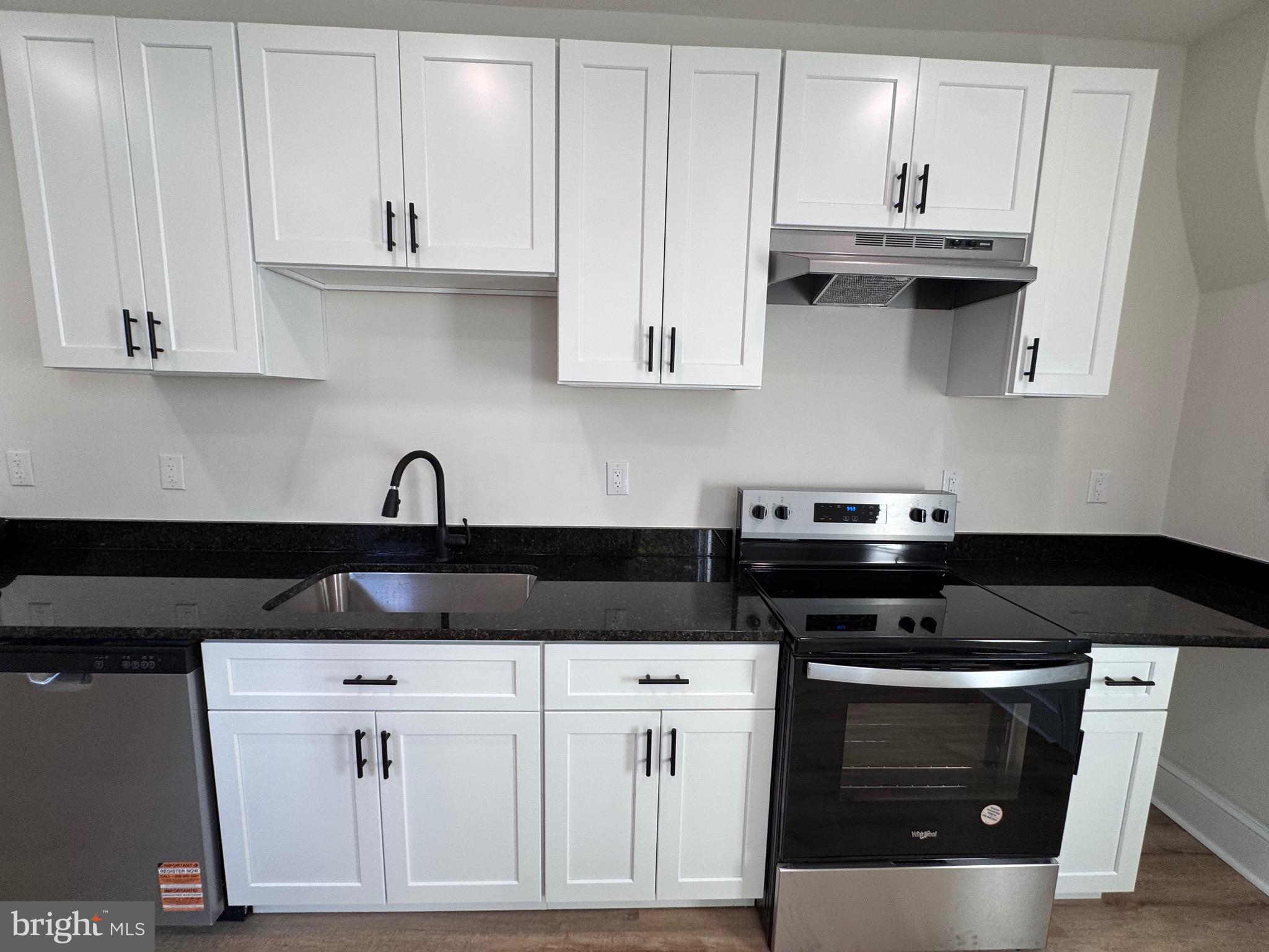 666 St Joseph Street, Unit 1A Lancaster, PA 17603 - Photo 2 of 8 a kitchen with stainless steel appliances granite countertop white cabinets and a stove