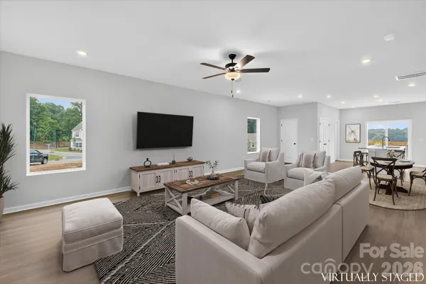 a living room with furniture a flat screen tv and a window