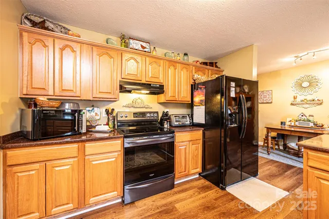 a kitchen with stainless steel appliances granite countertop a refrigerator stove and sink