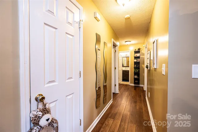 a view of a hallway with wooden floor and closet