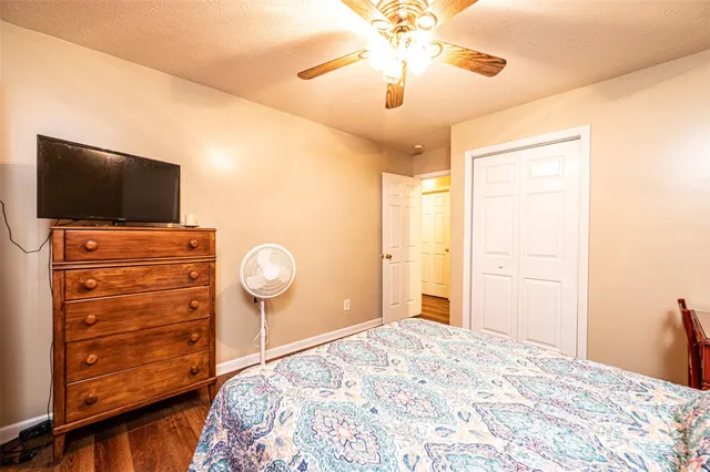 a bedroom with a bed and a flat tv screen on dresser