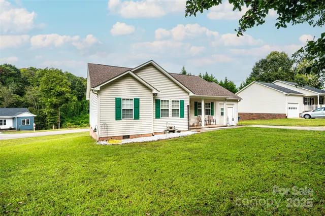 a view of a house with a yard and sitting area