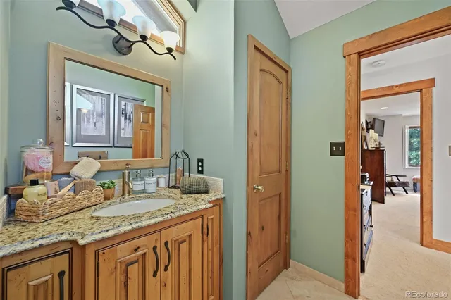 a bathroom with a granite countertop sink and a mirror