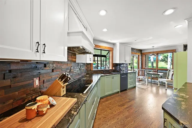 a kitchen with stainless steel appliances kitchen island granite countertop a stove and a sink