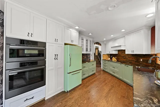 a kitchen with stainless steel appliances kitchen island granite countertop a stove a refrigerator and a microwave