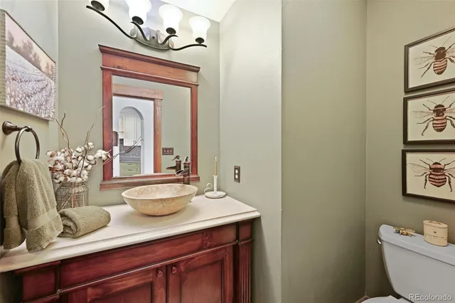 a bathroom with a granite countertop toilet sink and mirror