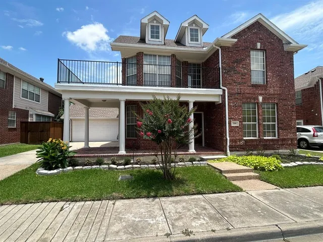 a front view of a house with a yard and potted plants