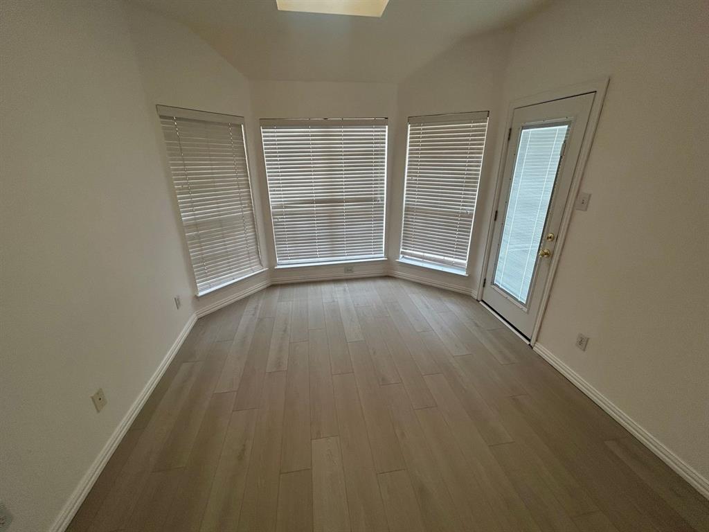 588 Southridge Way Irving, TX 75063 - Photo 14 of 26 an empty room with wooden floor and windows