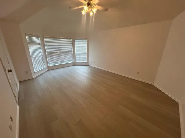 an empty room with cabinet and windows