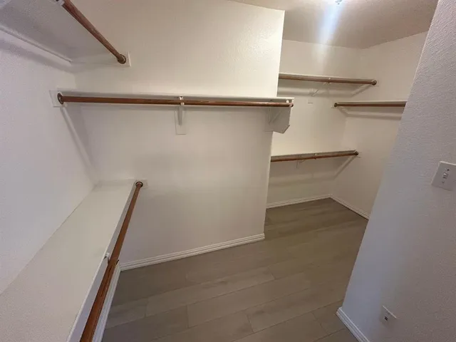 an empty room with wooden floor and entrance