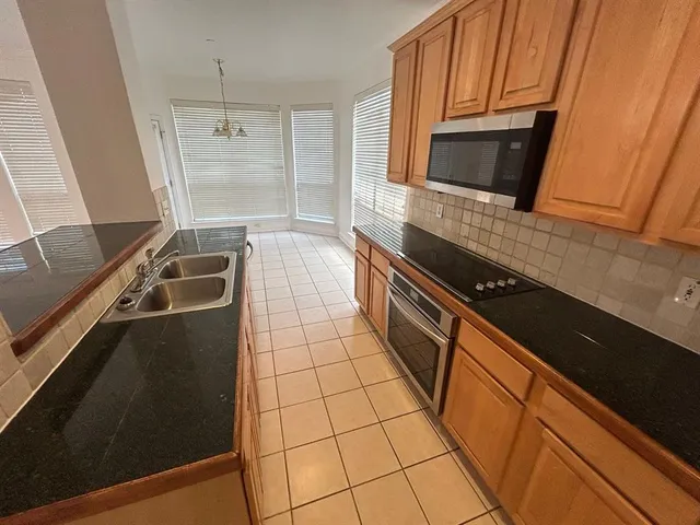 a kitchen with granite countertop a stove and a microwave