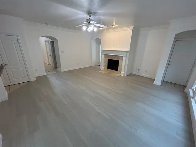 a view of empty room with fireplace and wooden floor