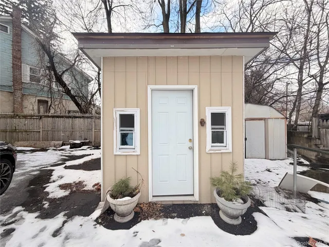 a view of a backyard with chair and potted plants
