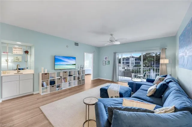 a living room with furniture and view of kitchen