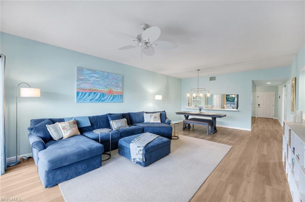 6030 Chardonnay Lane, Unit 203 Naples, FL 34119 - Photo 9 of 28 a living room with furniture and a wooden floor