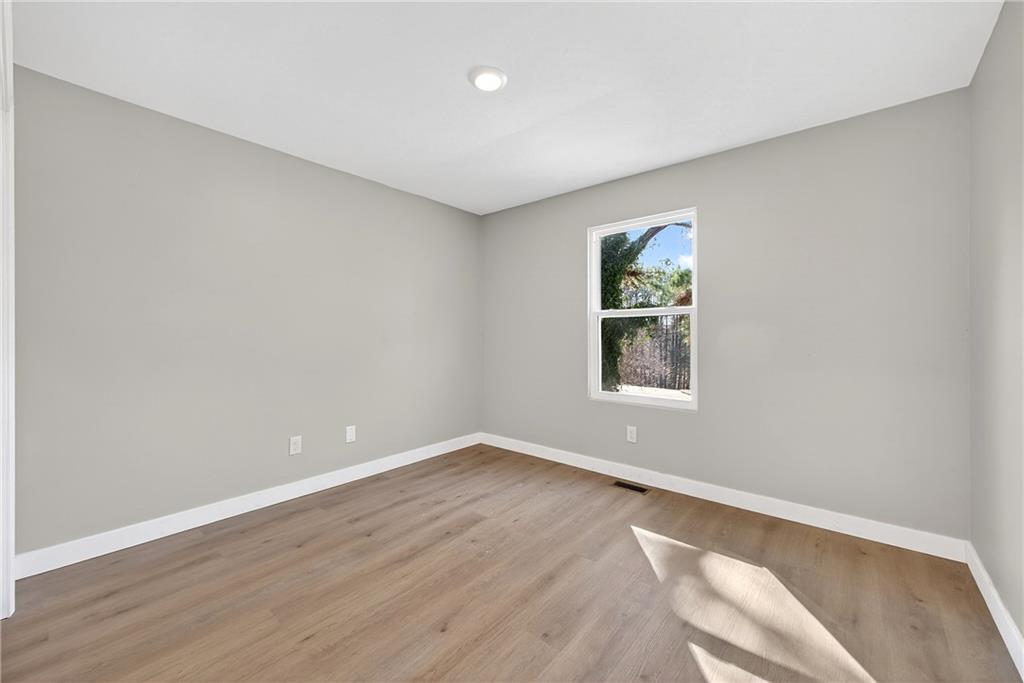2874 Fairburn Road Southwest Atlanta, GA 30331 - Photo 19 of 34 an empty room with wooden floor and windows