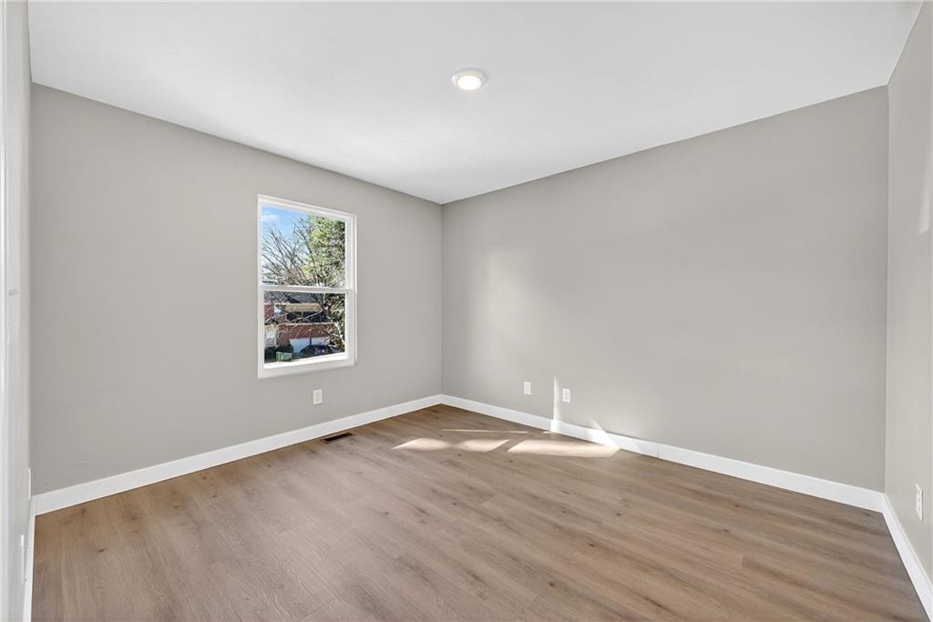 2874 Fairburn Road Southwest Atlanta, GA 30331 - Photo 20 of 34 an empty room with wooden floor and windows