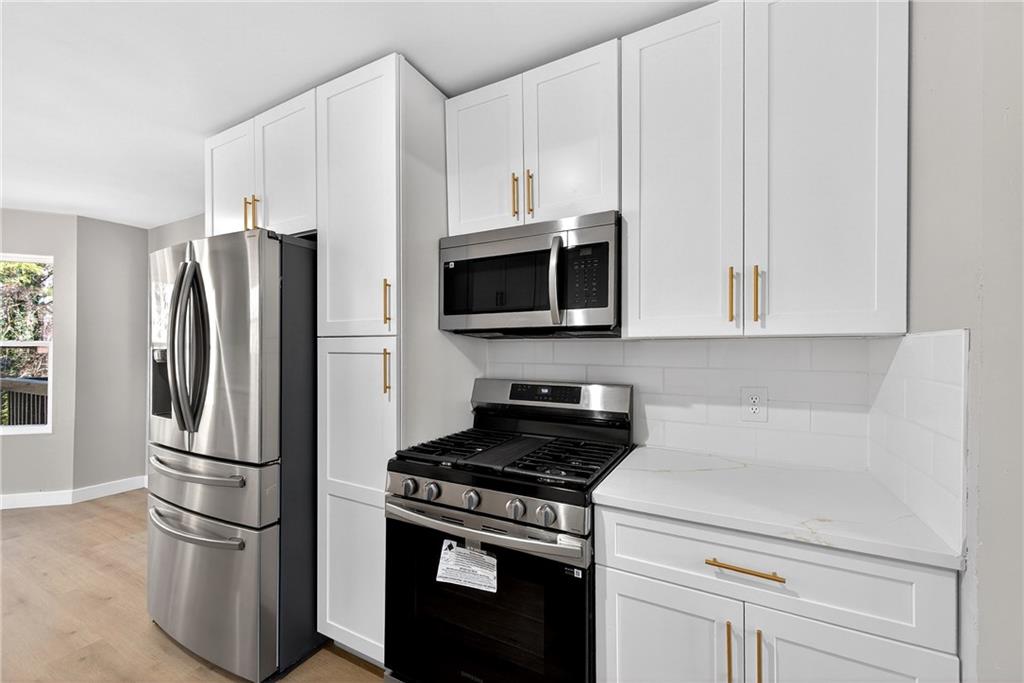 2874 Fairburn Road Southwest Atlanta, GA 30331 - Photo 9 of 34 a kitchen with stainless steel appliances a refrigerator stove and microwave