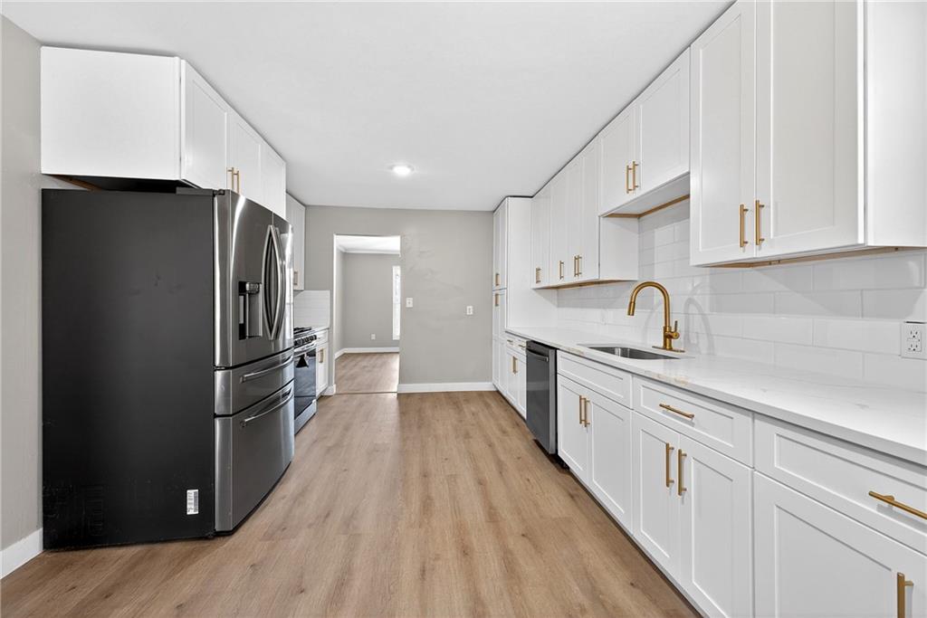 2874 Fairburn Road Southwest Atlanta, GA 30331 - Photo 10 of 34 a kitchen with stainless steel appliances a refrigerator sink and cabinets