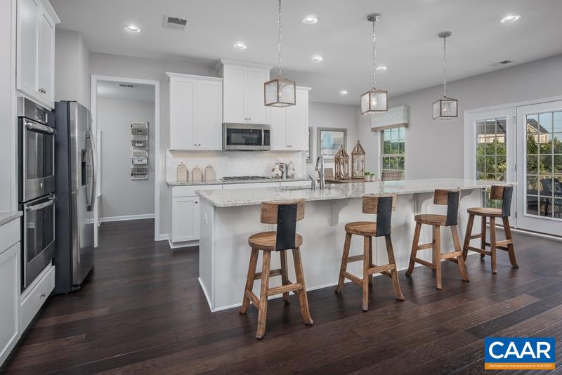 1617 Fowler Ridge Court Charlottesville, VA 22901 - Photo 5 of 23 a kitchen with stainless steel appliances granite countertop a dining table chairs refrigerator and sink