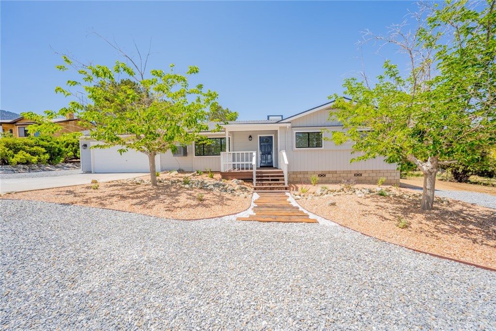 9846 Mountain Road Pinon Hills, CA 92372 - Photo 1 of 1 a backyard of a house with table and chairs