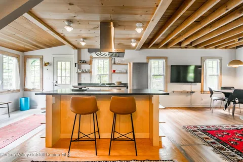 a living room with stainless steel appliances kitchen island granite countertop furniture and a flat screen tv