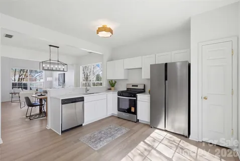 a kitchen with a refrigerator cabinets and wooden floor